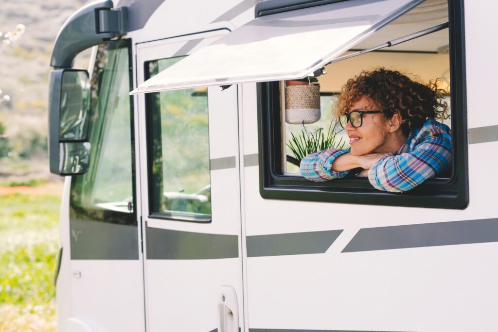 Happy tourist enjoy destination smiling outside the window of modern rented camper van motorhome rv